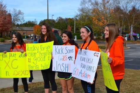 Seniors Maria Mesa, Jessica Luna, and Sarah Reagan, junior Riley O’Neill, and sophomore Mackenzie Union display homemade posters. The North Cobb Girls Varsity team spent the whole race cheering on the boys.
