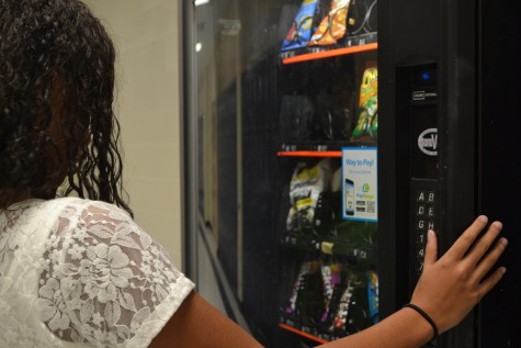 Freshman Tylan Eley struggles to decide between trail mix and popcorn. With the new restrictions on school vending machines, students choice of snacks are extremely limited. Tylan complained about the limited options.
