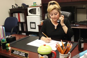 Mrs. Kolen, an expert multitasker, handles locker registrations and takes calls from parents.