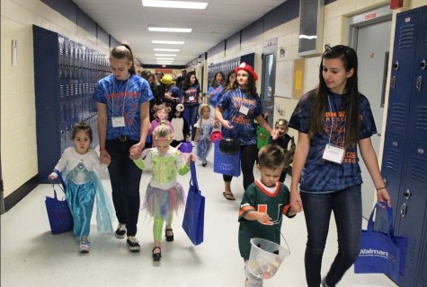 Students in the Early Childhood class help walk their trick-or-treaters to each classroom to greet students and grab goodies along the way.