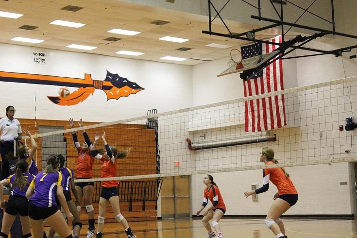 Juniors Taylor Parrish (10), setter, and Lizzy Daniel (7) , middle, attempt to block a hit from the opposing team.