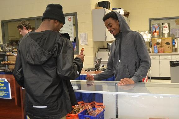 At the school store, senior Evan Drehger sells a beef jerky, a new item to the school store, to fellow senior Micah Law. “ We have a good variety of stuff to choose from,” said Drehger.
