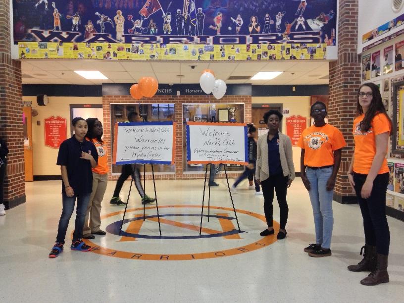 As morning dawned, students dressed in orange and blue stood at doors next to signs illustrating the location of the event. They were placed at the two main entrances as well as in the hallways. 