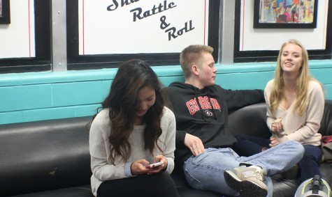 Junior Gina Lee, enjoying time on her phone, with her friends, junior Jack Pearson and sophomore Erin Bryant during lunch in the Magnet lounge. 