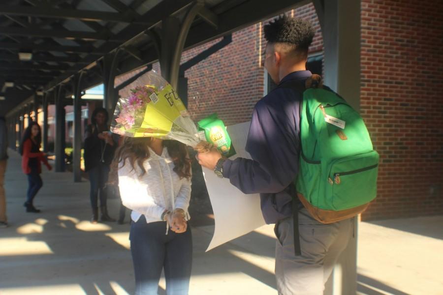 Junior Manoah Johnson promposes to junior Judy Beddawi early in the morning with her favorite flowers and snack,and a poster that says “You’ve traveled all over the world… now will you travel to prom with me?”