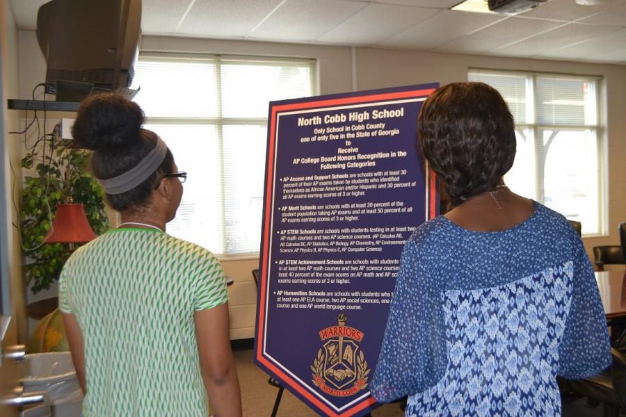 Juniors Laurie Francois and Mercedes Gray observe the poster board proclaiming NC’s latest achievement. The display stood proudly at the Magnet Open House. “I’m proud of North Cobb because we worked really hard to get where we are and the students deserve to be recognized,” said Gray. 
