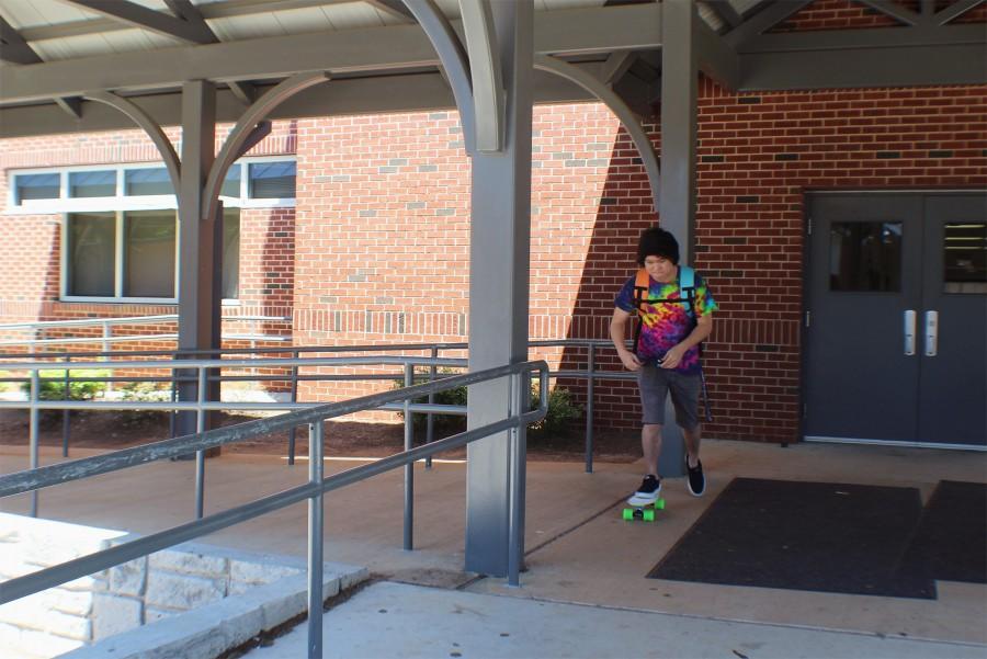 Sophomore Taylor Tallent rides down the breezeway during lunch on a penny board. “Taylor always has a lot of energy. It’s so fun to be around him,”  said sophomore Jarrel Garrett.