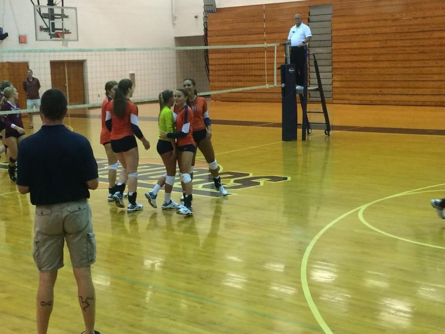 The Lady Warriors celebrate scoring a point as Coach Auld looks on.
