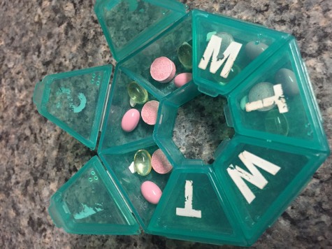 An organized pill container holds my daily medications.