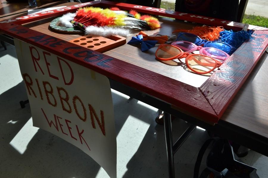 Students supporting Red Ribbon Week provide props for their Instagram contest. Students can pose for a picture and caption the photo with a Red Ribbon Week concept to win gift cards to various local businesses. 
