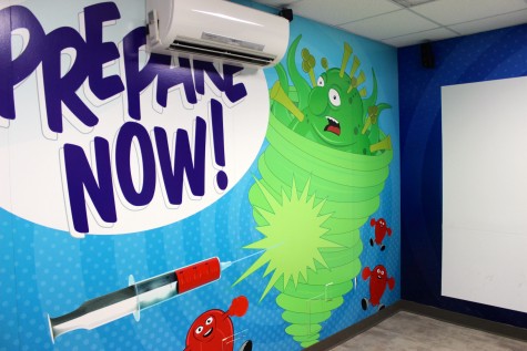 Inside the Cobb and Douglas Public Health building, an interactive screen and projector involve kids in washing their hands and evading sickness.