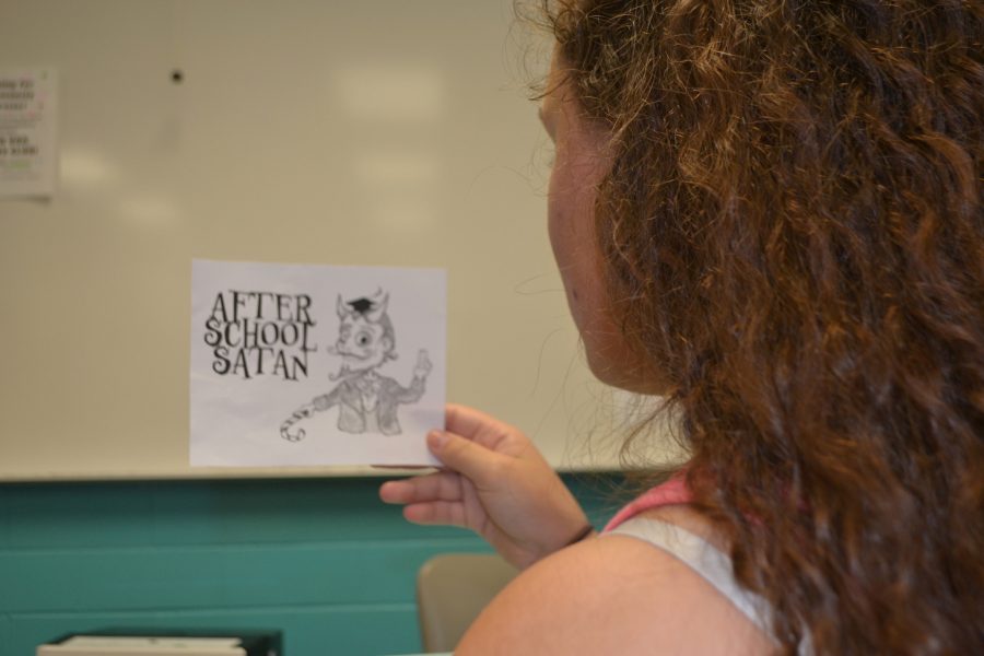 An NC student looks at an ad for the new After School Satan Club, run by The Satanic Temple.