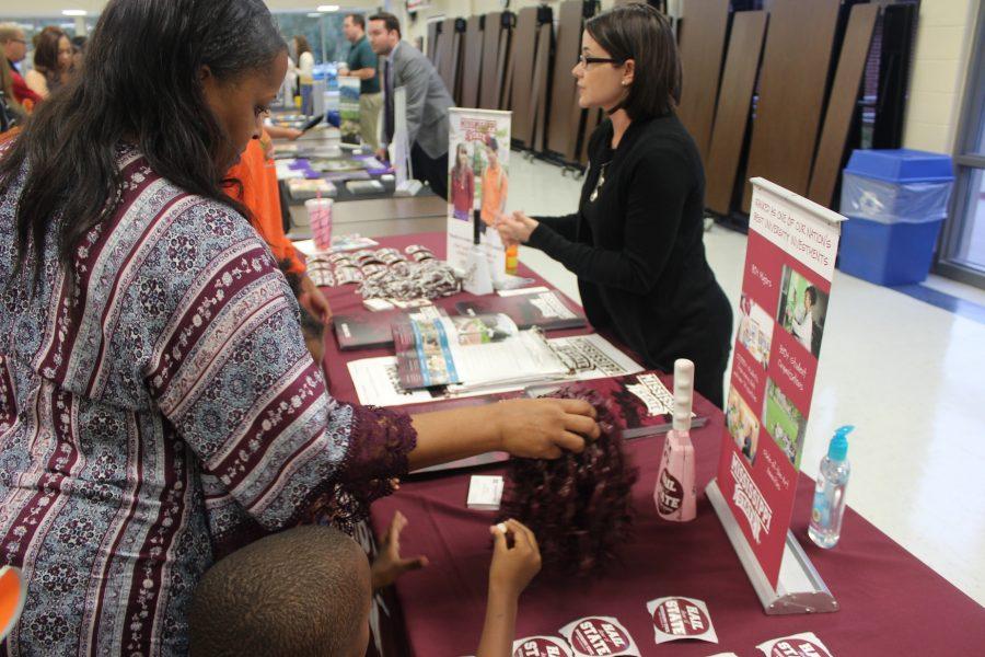 College admissions officers visited NC last Thursday to give students advice on college and the application process. Representatives from colleges in Georgia, Alabama, Tennessee, Mississippi set up tables covered with pamphlets and informational papers about their school. A Mississippi State spokeswoman pictured above helps families by answering specific questions handing out college merchandise.
