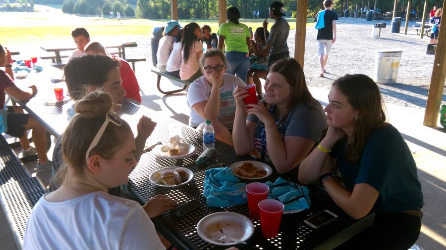 NHS members Alison Adams, Sarah Baker, Jessica Campbell, Josh Joines, and Rebecca Cantrell dine at a picnic table. After dinner, members played games, ran to the playground, or spent time in the dog park.
