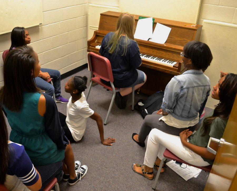 Chorus class sings their way into the school year for their third sectional group meeting of the year. Sectional groups practice singing in individual rooms to perfect their tone and pitch. Alto 2 leader and junior Kara Yancy plays piano while fellow chorus members sing along, practicing for their first concert on November 16. When we sing together its like were in harmony, freshman Evyna Milligan said.
