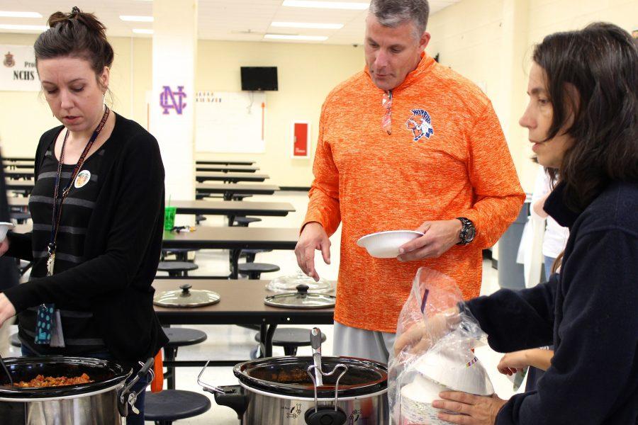 NC faculty Jenna Essenburg and Matthew Tener sample the options at the teacher chili cook-off.
