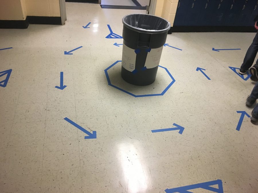 Blue arrow-shaped tape covers the floor of Malfunction Junction with a trash bin in the center. The newly set-up round-about designed to help ease traffic perplexed NC students. “We’ve been working on lots of different solution for a few weeks, and you’ll see several different possible solutions for this problem. So, there were kids that are in a mentorship programs that have gotten together with people in business and have gone over how people deal with traffic flow,” said Adam Cogbill, teacher of Engineering and Technology. The collection of data from the success of their designed solutions will act as a test for students in the class. 
