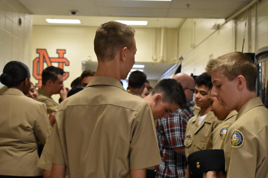 Group of student cadets stand in the outer gym lobby as they await to enter the gym for their inspection. 