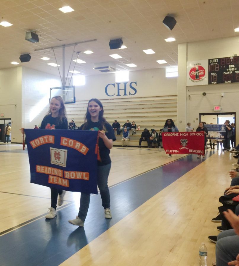 Sophomores team managers Ally Ward and Maddie Sullivan carry their team’s banner during the Parade of Teams in the opening ceremonies. “I liked managing it, and next year I hope to start earlier and to become even more organized than before,” Sullivan said.