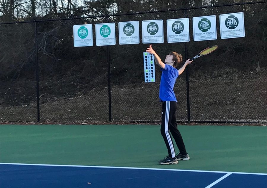 NC tennis player practices his serve and makes the first hit to begin the point and prepare for the tennis season.