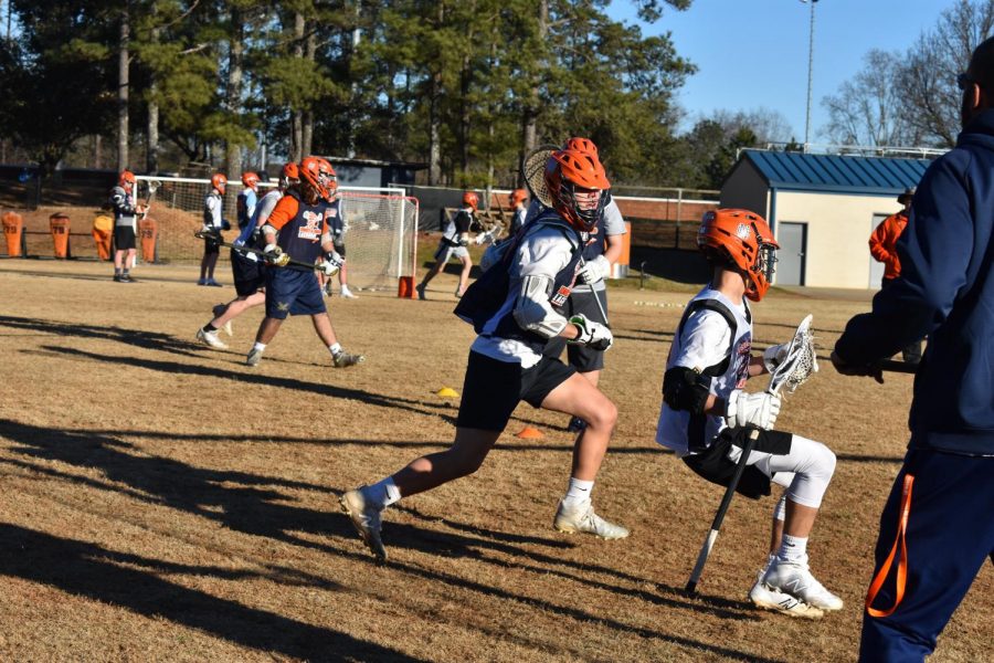 Sophomore+Brendan+Rice+and+junior+Noah+McKouen+practice+their+slide+package+in+an+important+defense+drill.+Through+improving+essential+lacrosse+skills%2C+the+team+better+prepares+themselves+for+their+upcoming+season.