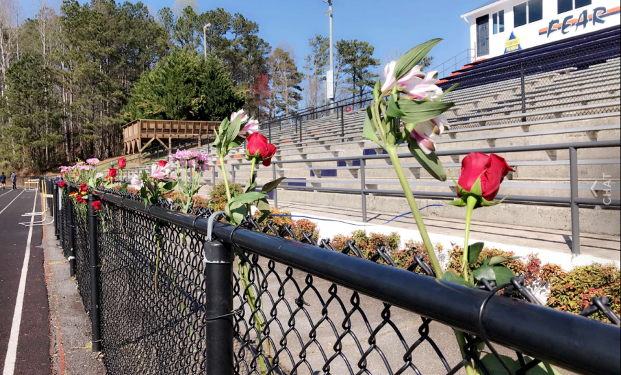 Students+brought+flowers+to+line+the+fence+on+the+field+where+the+memorial+took+place.+The+brainchild+of+administration+and+select+leaders+from+each+grade%2C+the+ceremony+aimed+to+commemorate+the+teens+and+adults+who+fell+victim+to+the+Valentine%E2%80%99s+Day+massacre+at+Douglas+County+High+School.+%E2%80%9CImagine+if+we+came+together+like+this+all+the+time.+We+wouldn%E2%80%99t+be+having+these+conversations+about+gun+reform+and+school+shootings+if+we+were+constantly+supporting+each+other%2C%E2%80%9D+senior+Kaylin+Altman+said.