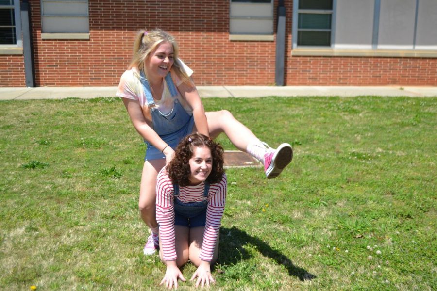 Students jump into Kindergarten day as they start the senior dress up week. Seniors Chelsea Scarborough and Maddy Bilbrey dress up with sandals, high socks, and pigtails. The two school children play leap frog during lunch in the courtyard. Students will lay out their outfits for tomorrows theme of purple out, in memory of the student Arielle Sterrett.