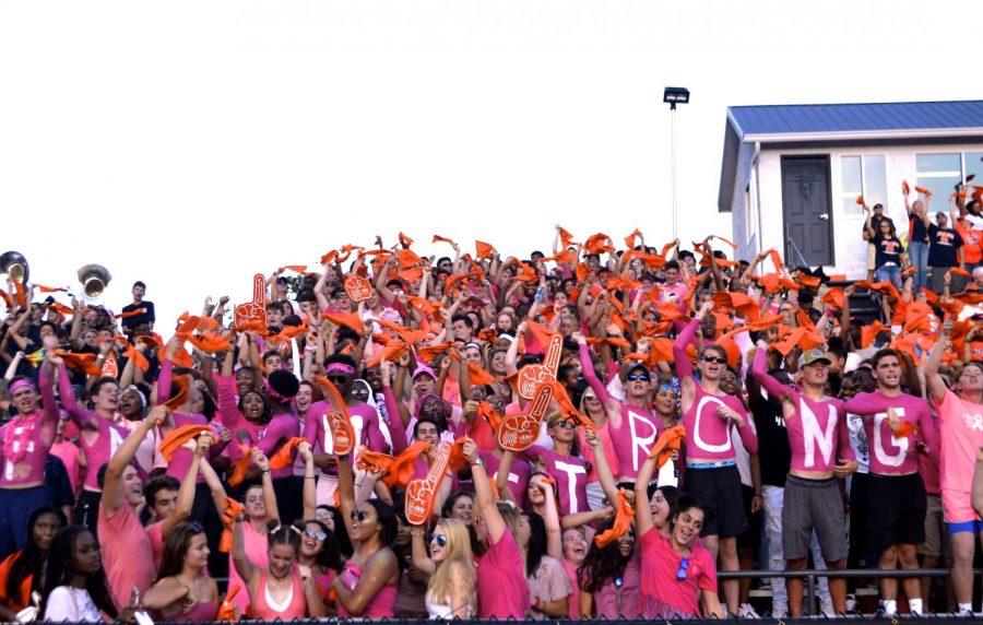 The+student+section%2C+clad+in+all+pink+for+the+pink+out+in+support+of+their+fellow+warrior+junior+Fatima+Asad%2C+celebrates+the+first+touchdown+of+the+game+by+waving+their+orange+spirit+towels.+%E2%80%9CWe+are+pink+for+Fatima%2C+being+a+nation+means+never+standing+alone%2C%E2%80%9D+senior+class+president+Chike+Asuzu+said.