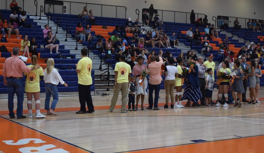 The senior volleyball players and their families line up shortly before the start of the game to address the crowd. The seniors honored include (in order of appearance) Taylor Hall, Jada Reed, Isabella Rodriguez, and Alison Weigel.