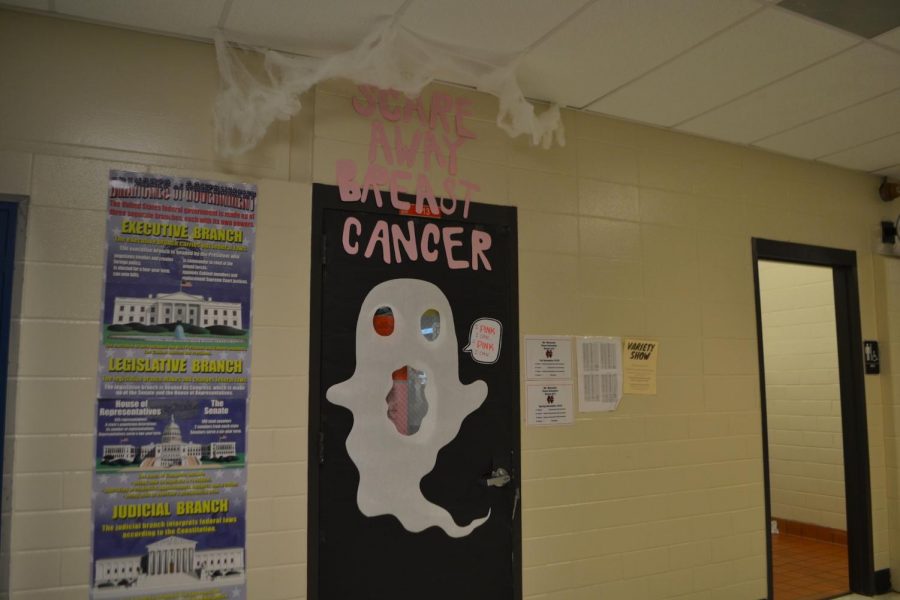 	Students celebrate Breast Cancer Awareness month by decorating classroom doors with creative spooky themes. Next Monday, judges will determine whose class wins the prize basket full of snacks. “Isabella Keaton and Adrienne Schuller took charge of our door. They decided to theme it up with Halloween and saying ‘scare away’ breast cancer. I love the idea, but they have full credit for it,” Economics teacher Marcus Marenda said. 