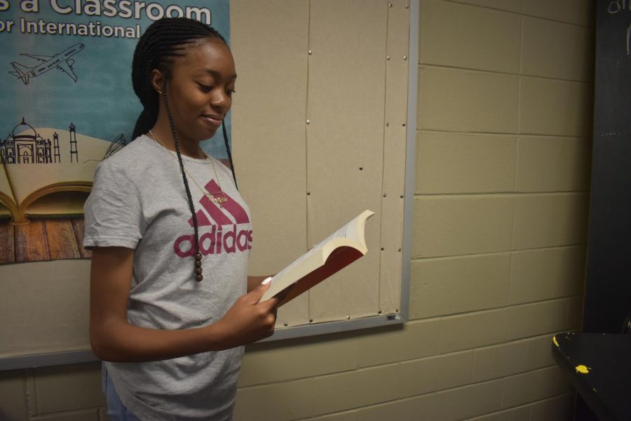 Magnet junior, Precious Ajero stands reading a book to learn about college and the college application process. Ajero takes science and math class to prepare her for her future. She plans to follow in a career as a pediatrician and study at Emory University.