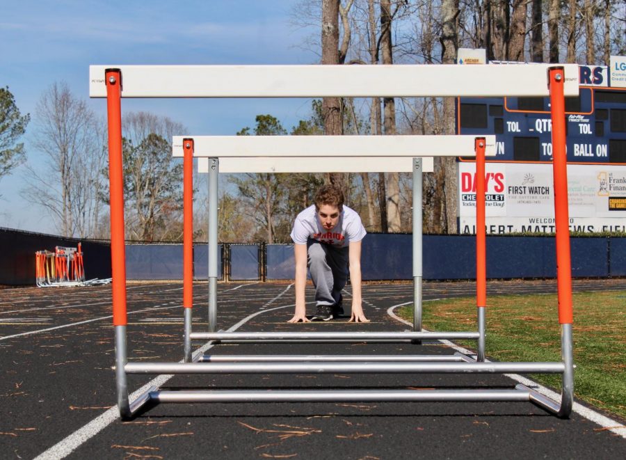 Magnet junior Isaac Stobo prepares to jump over this season with success. After three years  of NC track, Stobo hopes to make it to state and improve his time in the long distance events he runs. “This year my main goal is to make it to state and to accomplish this I am not going to get sick since I missed half of the season last year,” Stobo said. 