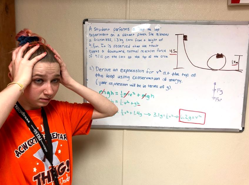 	Senior Rachel Maxwell looks in horror upon one of the typical AP style questions in AP Physics 1, dealing with rotational motion. The problem requires students to look at the situation conceptually, and only deal with variables and not numbers. This skill takes practice and shows up on the AP exam quite often.