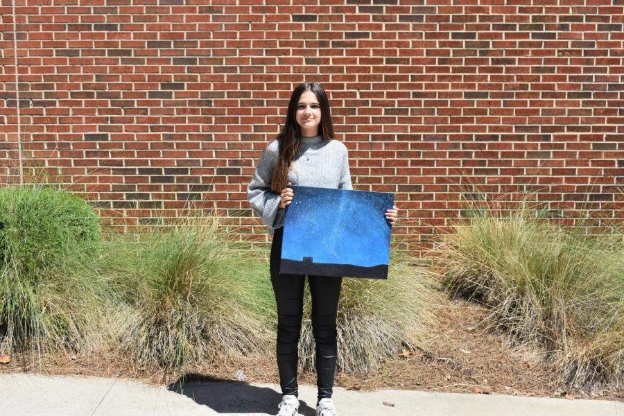 International exchange student, Aixa Rúa Rodríguez, stands on her temporary school campus sharing one of her paintings from her AP Drawing and Painting class.  The painting features a star-filled night sky presumably from her hometown of Boadilla, Spain. As a sibling of a former exchange student, Rodriguez came with a good understanding of life in America.