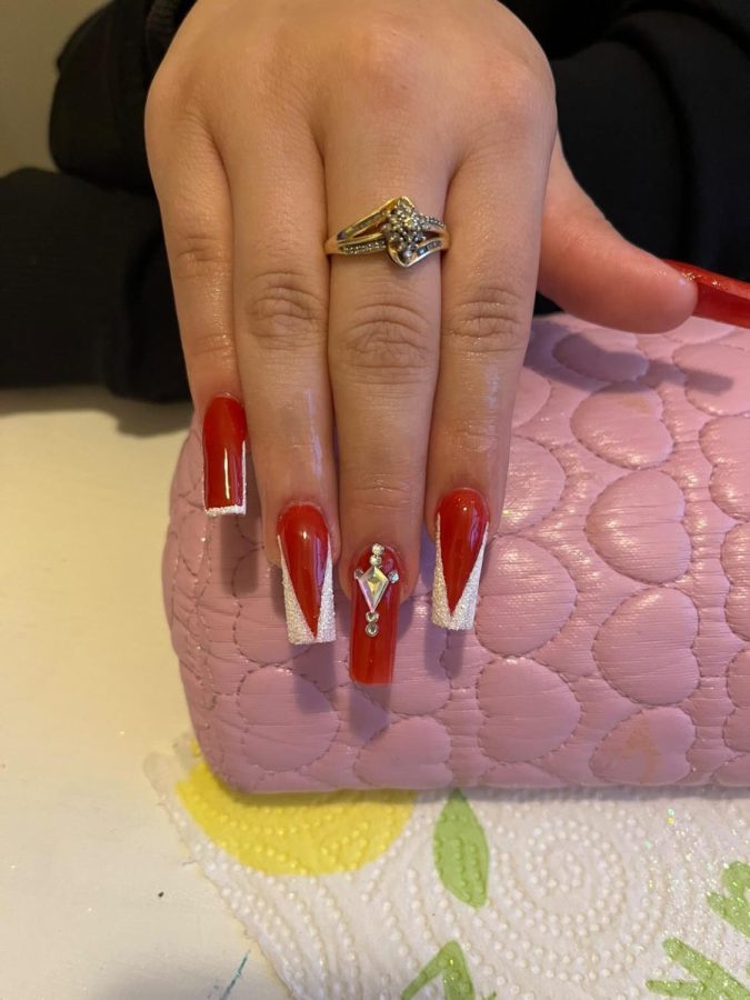 Gonzales created these classic and elegant nails in mid-December. She claims these nails as one of her favorite sets because of how the red adds a graceful look and the shiny rhinestones make them stand out. The nails consist of dark red nail polish with a glitter white french tip on the index, ring and pinky finger.