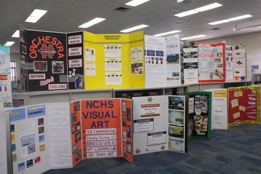 NC students and teachers displayed poster boards in the media center today for elective registration. The elective classes worked diligently and demonstrated their creativity while working on the poster boards for NC students. Rising 9th graders viewed the poster boards as they toured the school for their upcoming year at NC. Administrators and counselors assisted students today with scheduling making for the upcoming 2022-2023 school year.