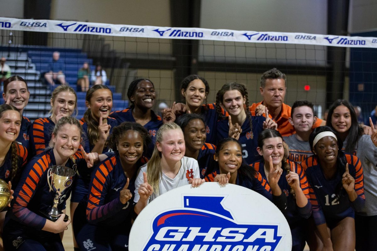 NC Lady Warriors Volleyball smile with their State Championship sign after their win against Walton.