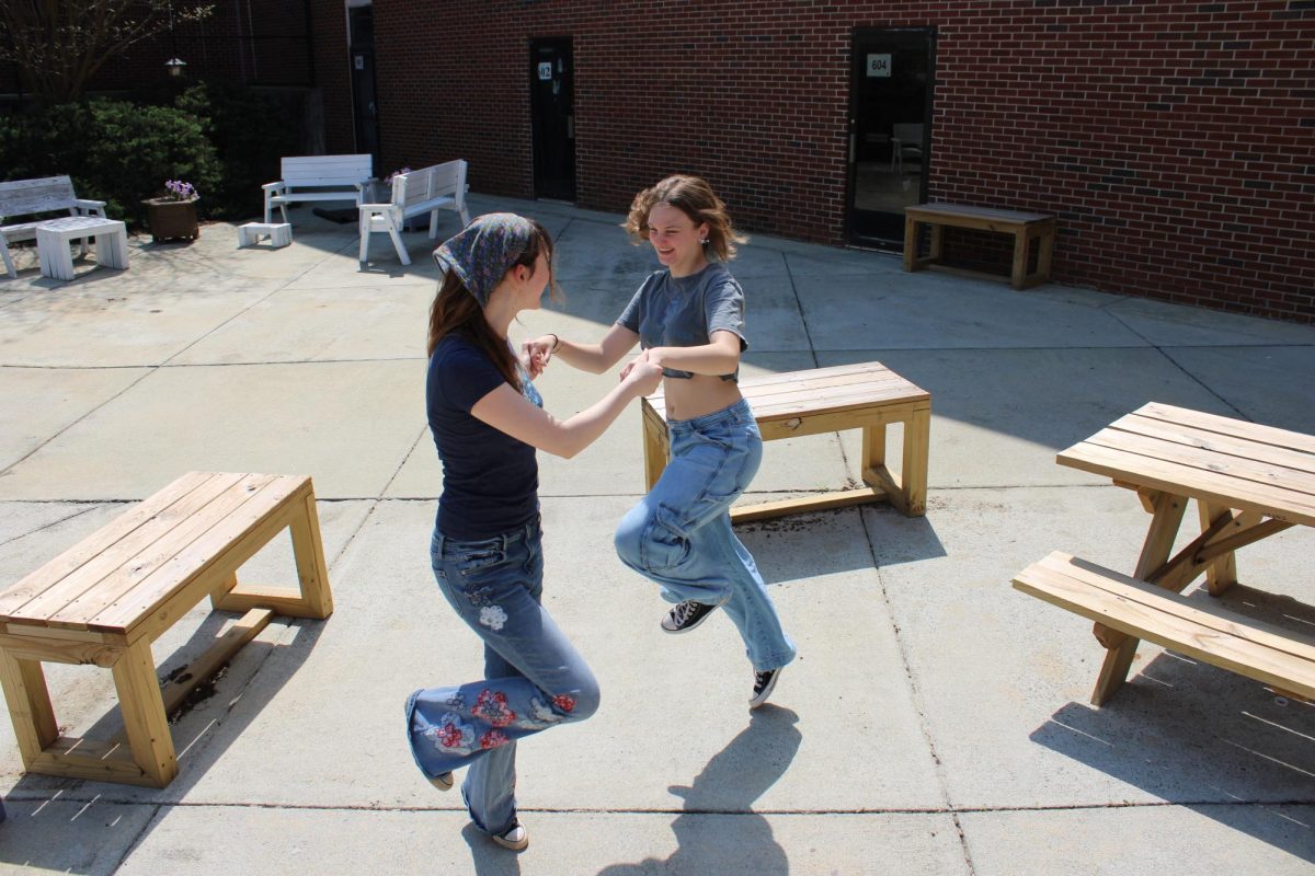 Seniors Cassidy Lumpkin and Rosalyn Schwanke frolic happily across the courtyard as they prepare to participate in the senior stargazing night.